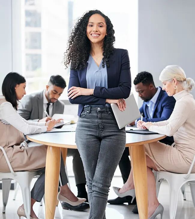 A professional standing in front of a team meeting