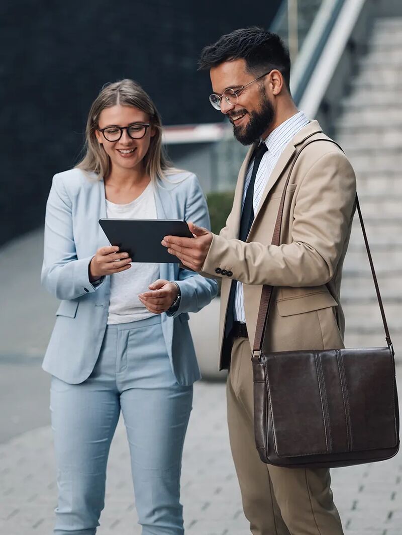 Two colleagues talking over a tablet outdoors