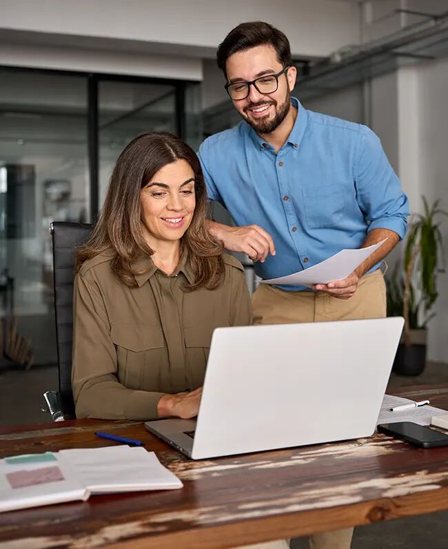 Two colleagues discussing work at a laptop