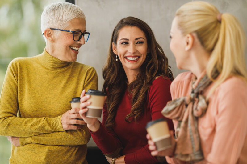 Three colleagues talking over coffee in an office break area