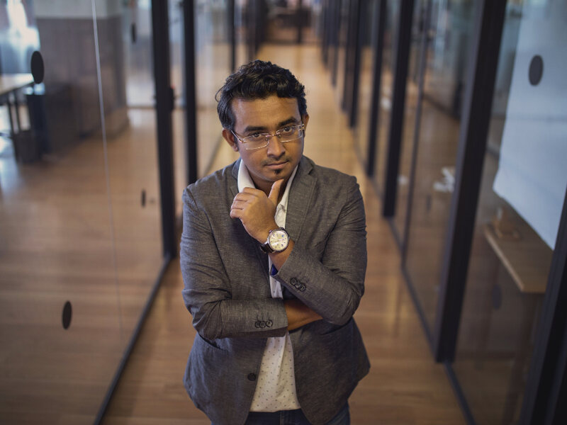 A campaign manager reviewing plans in a modern office corridor
