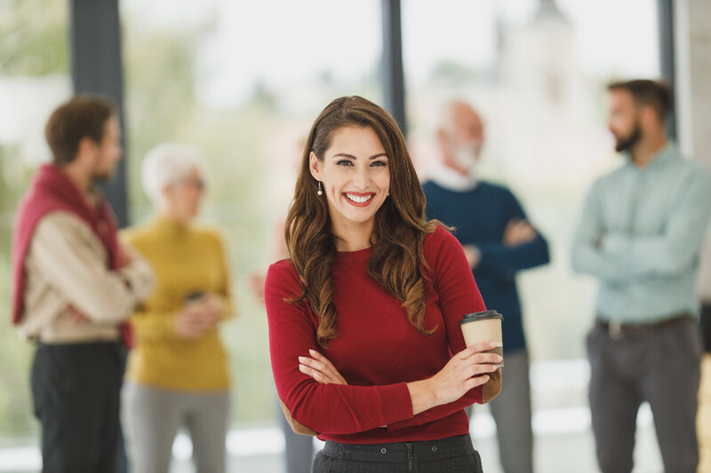 A sales team leader standing with colleagues in a bright office
