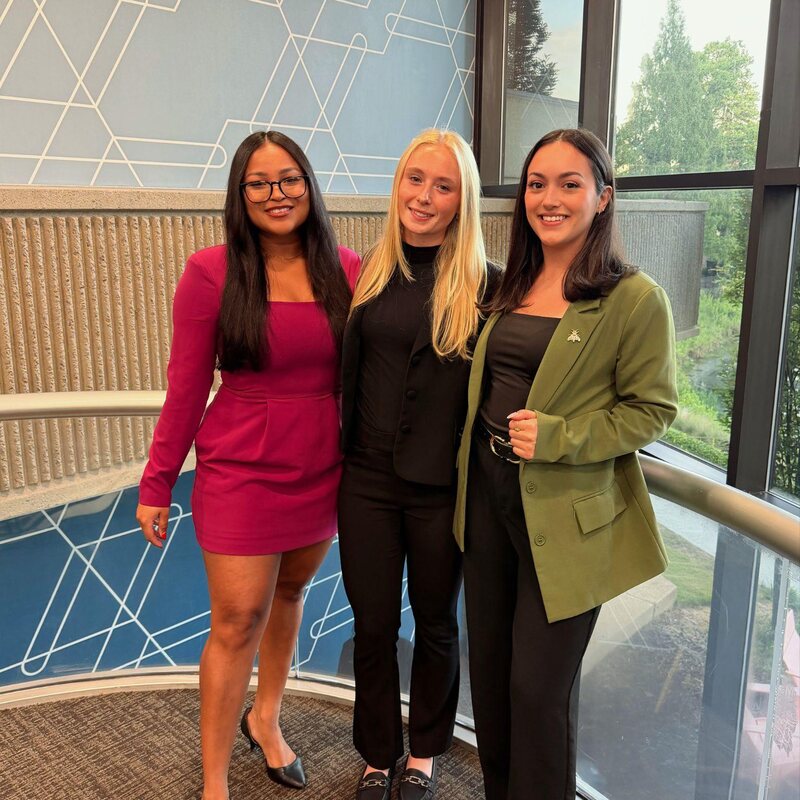 Three TriMkt team members at a conference venue