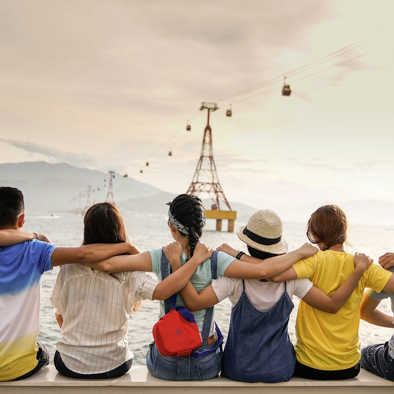 Group of friends sitting together outdoors looking out at the view