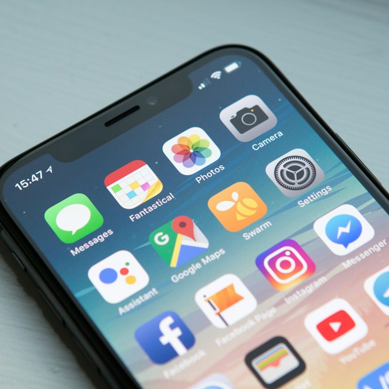 Close-up of a smartphone home screen held in hand