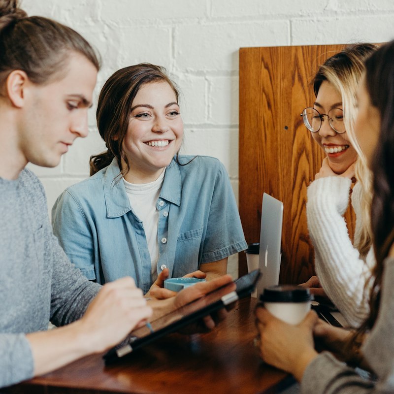 Young professionals smiling around a table during a team meeting