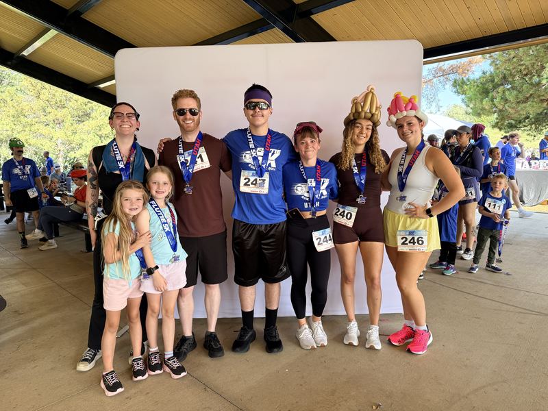 Clarity team members and family at a community fun run, wearing race medals