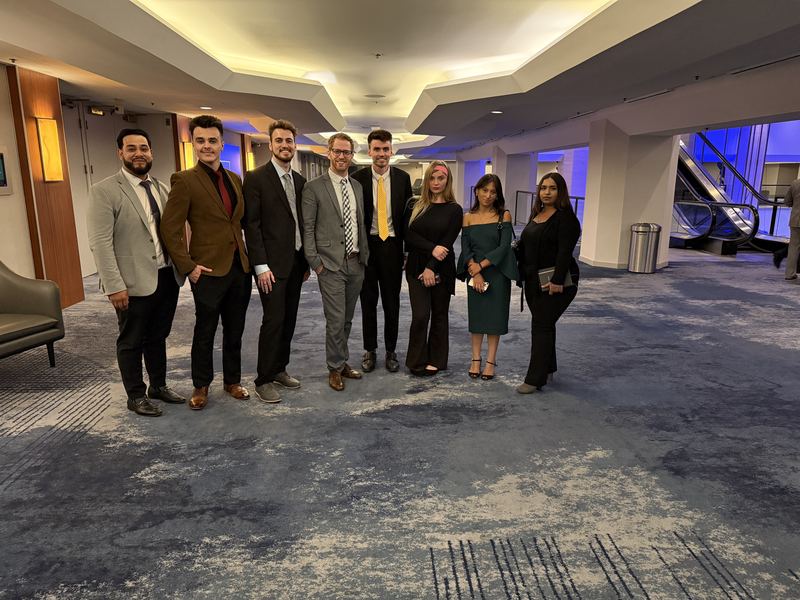 Clarity Acquisitions team dressed professionally at a conference venue