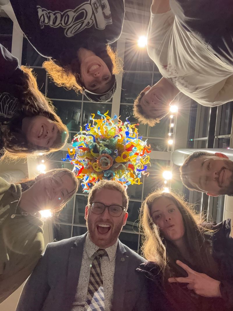 Team selfie under a colorful glass chandelier