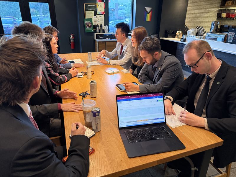 Clarity team members planning a campaign around a laptop at a cafe table