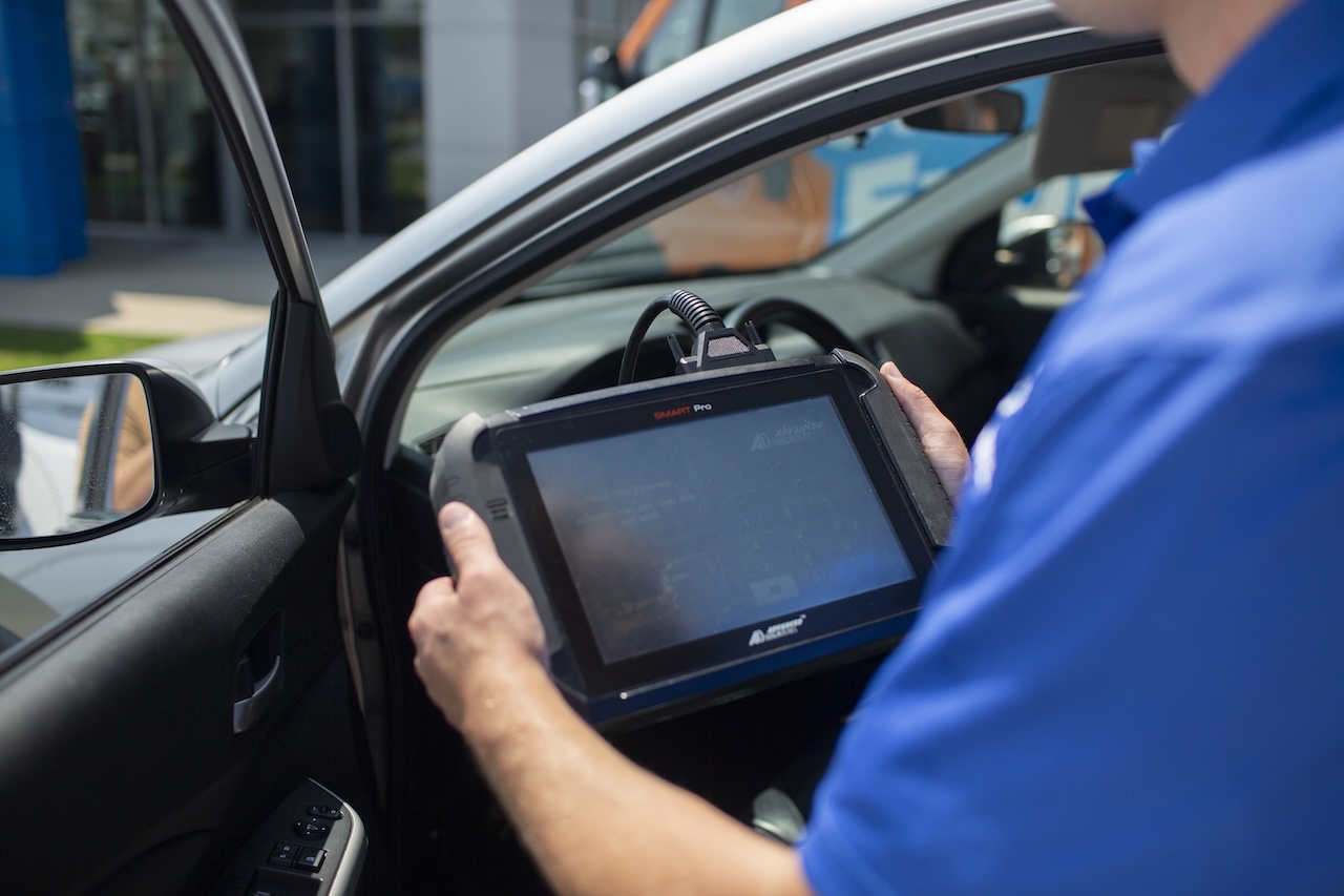 Technician using SMART Pro programming device for smart key programming