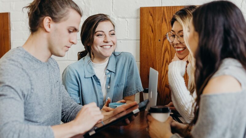 A group of team members collaborating and laughing around a shared table