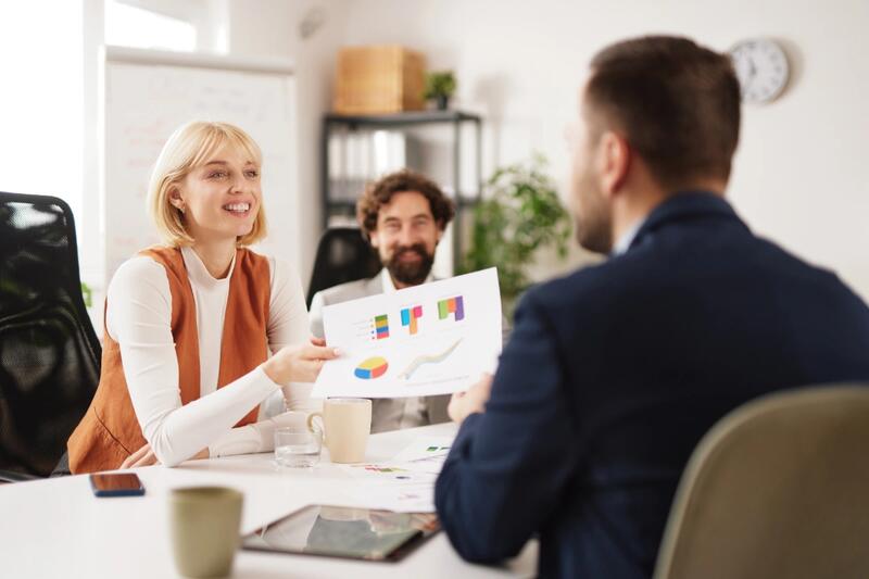 Colleagues discussing charts at a meeting