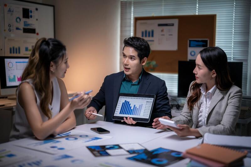 Representative presenting data on a tablet to two colleagues