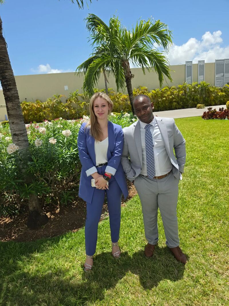 Two Kalispell Concepts team members in business attire outdoors under palm trees