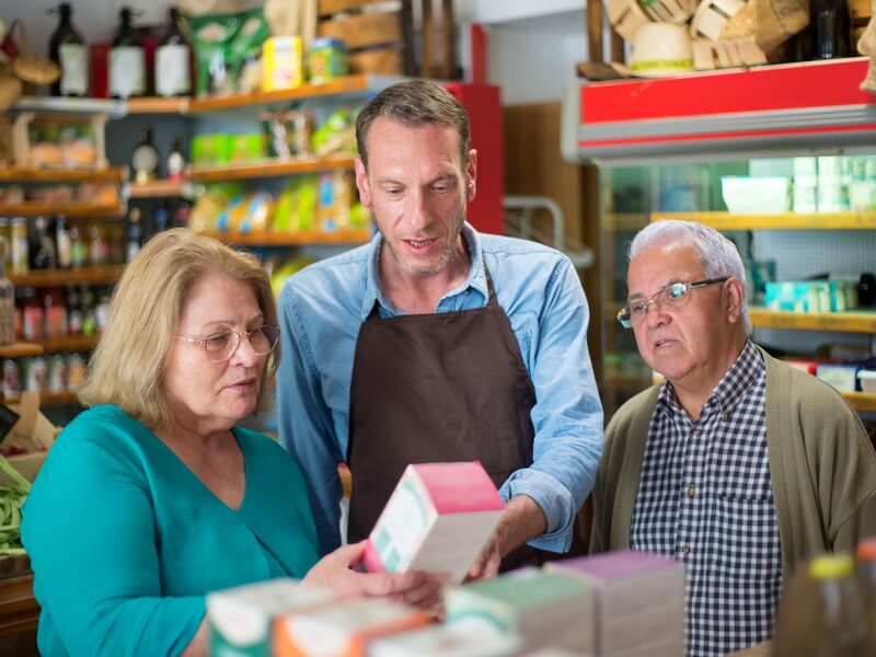 A retail associate helping shoppers at a store counter