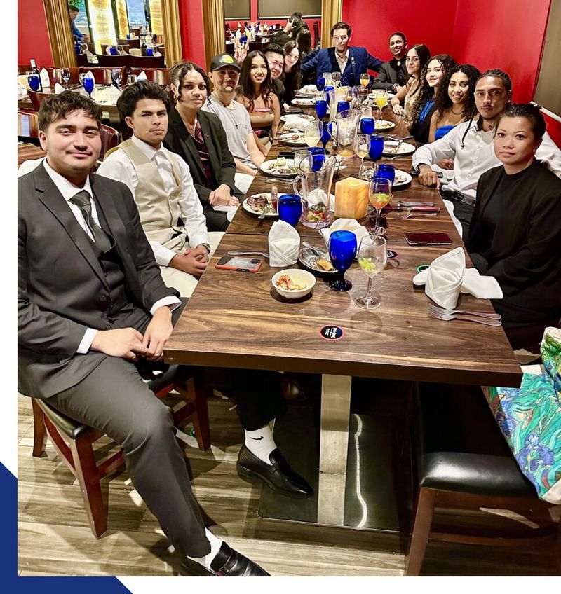 Mission III Management team gathered around a long table at a team dinner