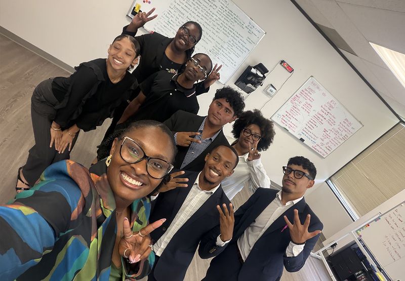 Mission III Management team members taking a group selfie at the office