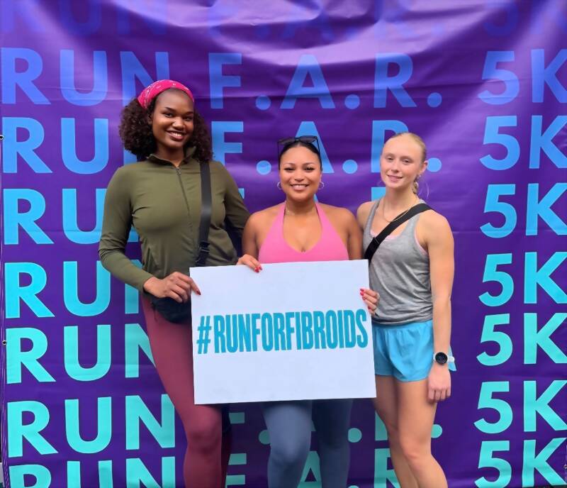 Team members holding a Run For Fibroids sign at the Run F.A.R. 5K