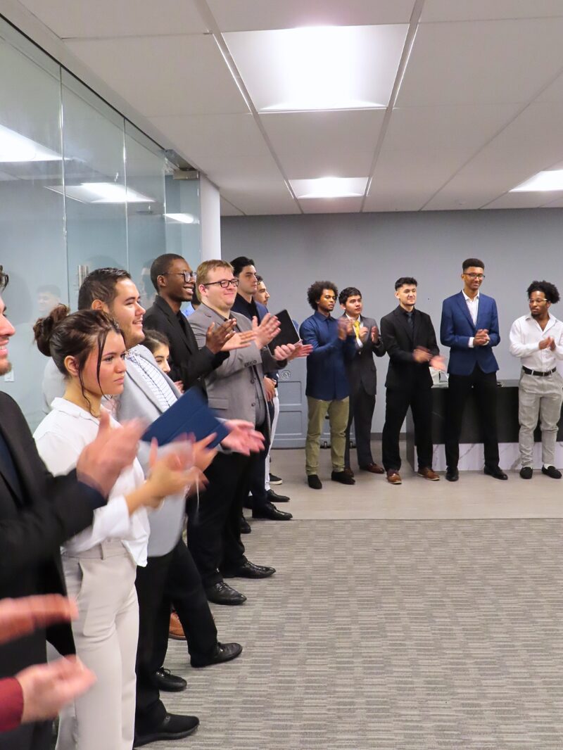 NoeCee Global team members applauding a colleague during a morning meeting