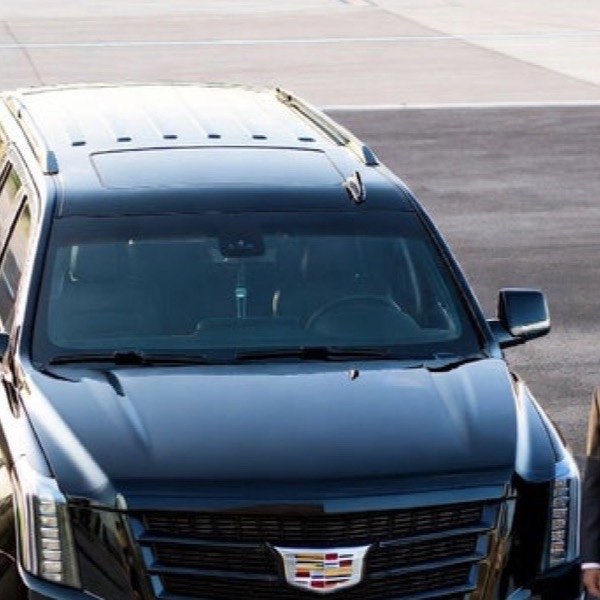 Cadillac Escalade at the airport curb for a meet-and-greet airport transfer