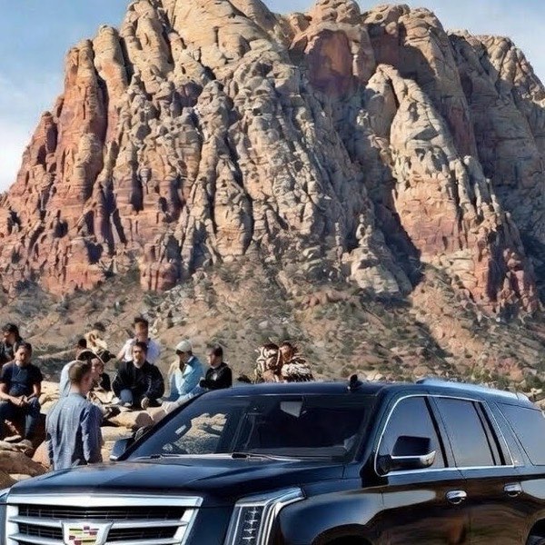 Group of passengers boarding a Cadillac Escalade for group transportation