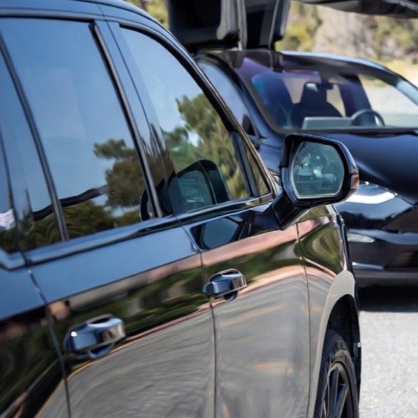 VIP black car service vehicle waiting curbside for a private client