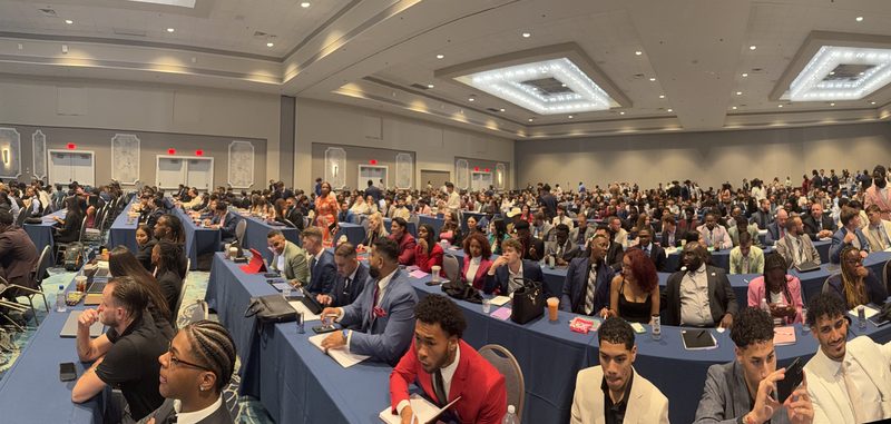 Hundreds of representatives seated at tables during a national sales convention
