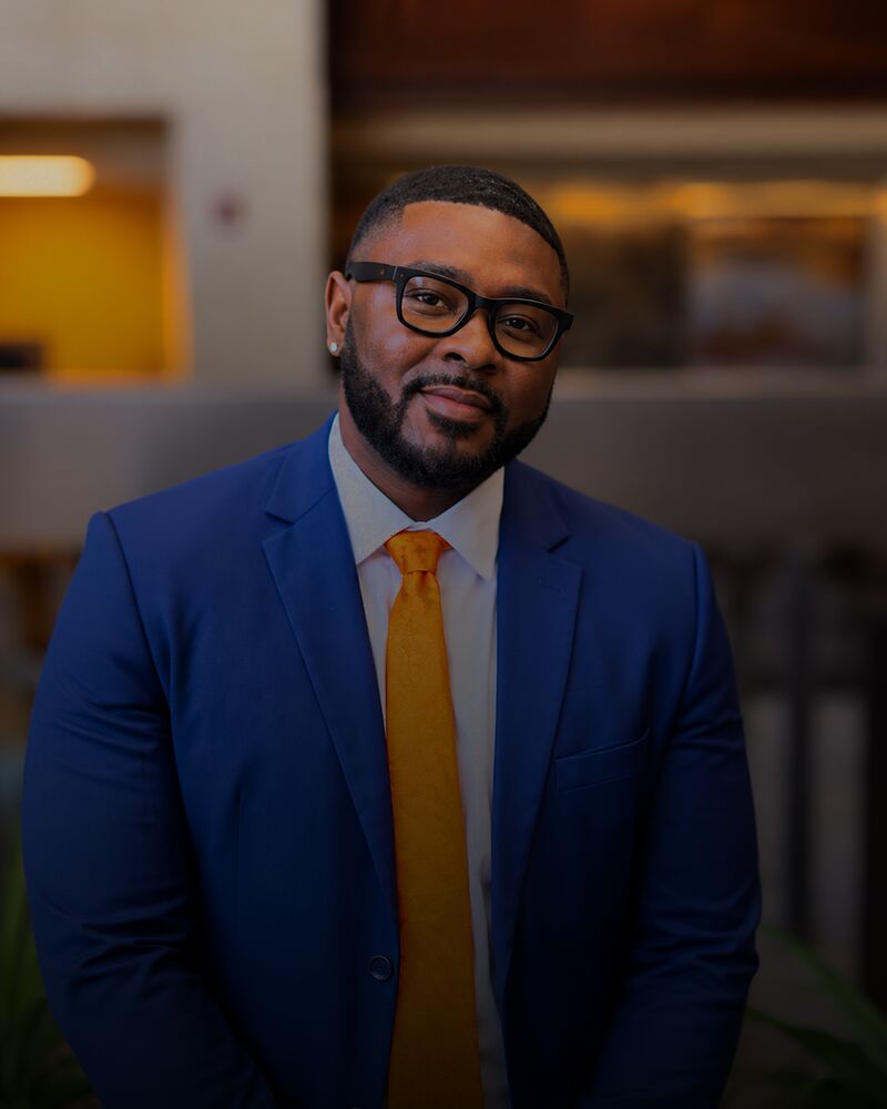 Tj Cromer, owner of Onias Marketing, in a blue suit and orange tie at the firm&rsquo;s Tallahassee office
