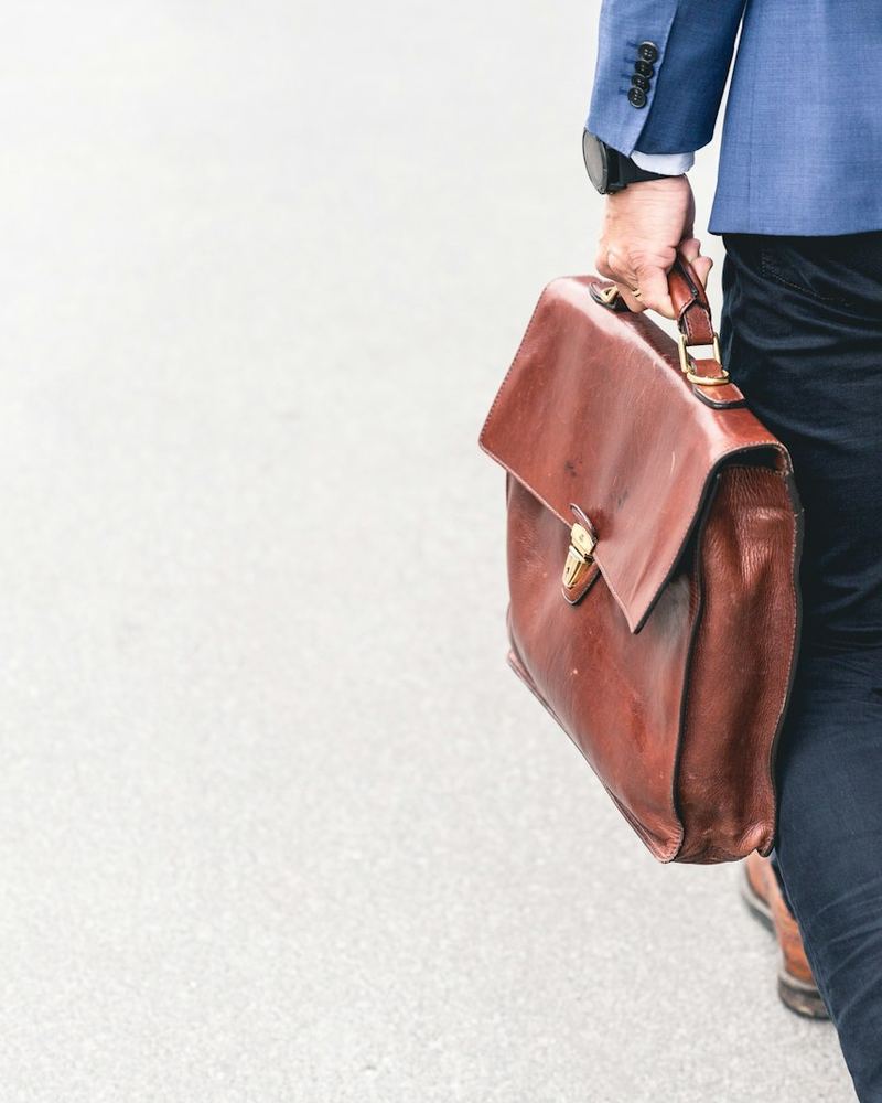 Outside sales representative walking to a client meeting with a leather briefcase