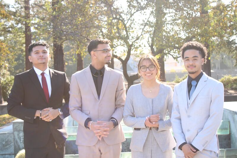 Four Sora Acquisitions team members in suits standing outdoors