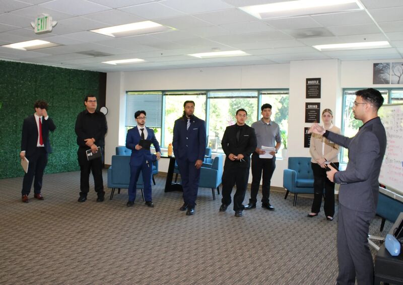 Sora Acquisitions team listening to a presentation in the office