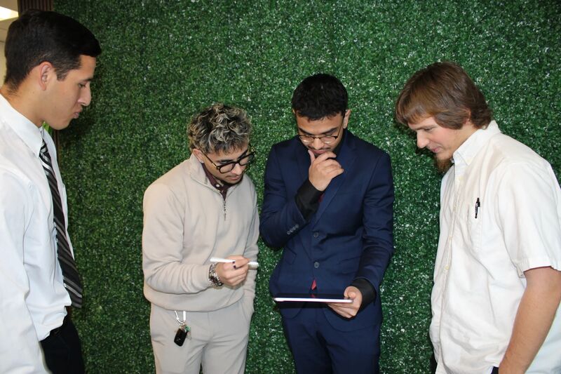 Three Sora Acquisitions representatives reviewing materials on a tablet