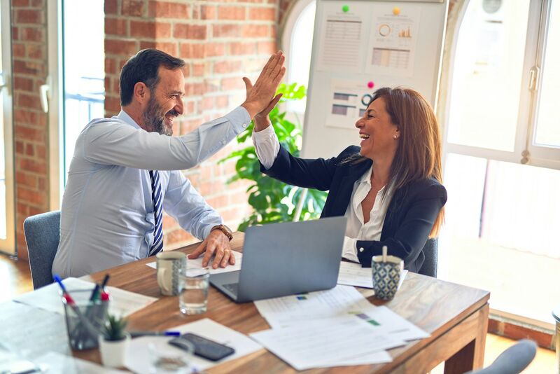 Two colleagues sharing a high five after a successful meeting
